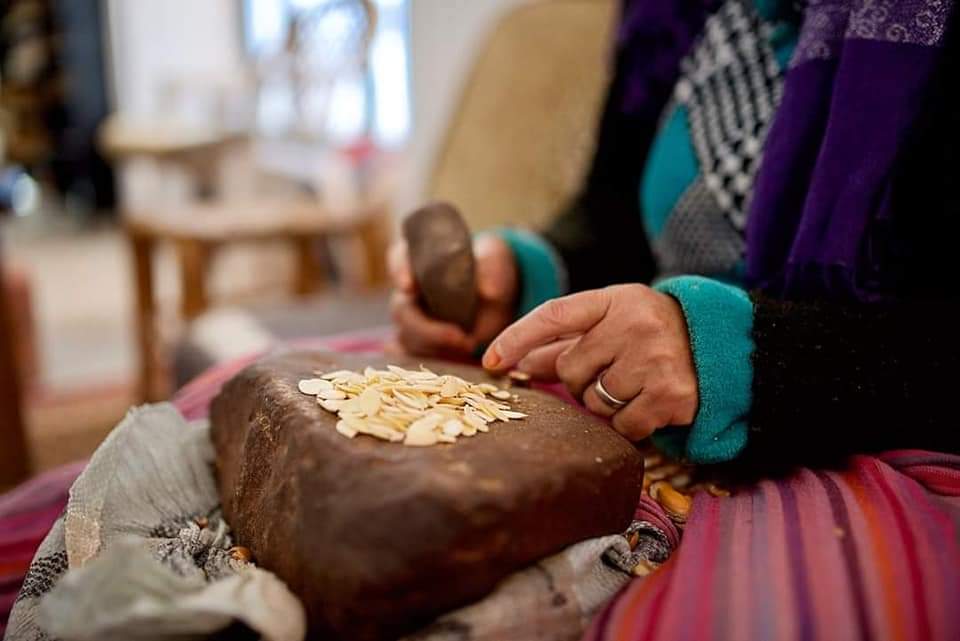 Mujer bereber trabajando con semillas de calabaza en Marruecos